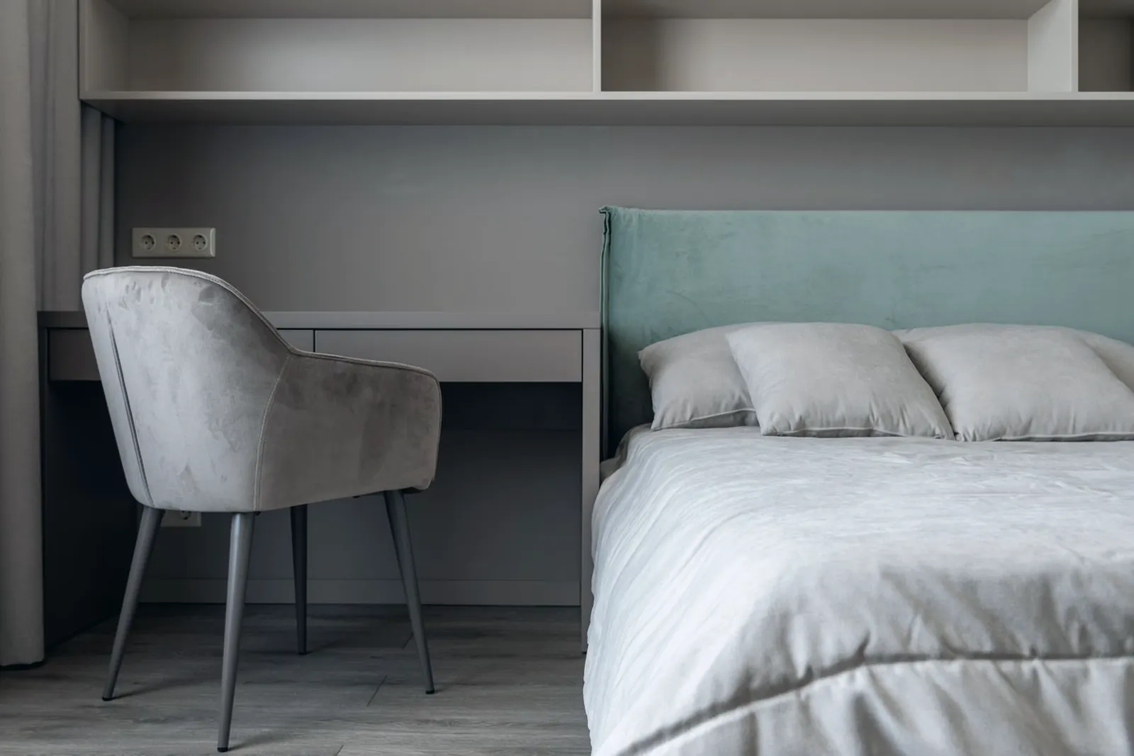 Chambre contemporaine avec tête de lit capitonnée, bureau et fauteuil