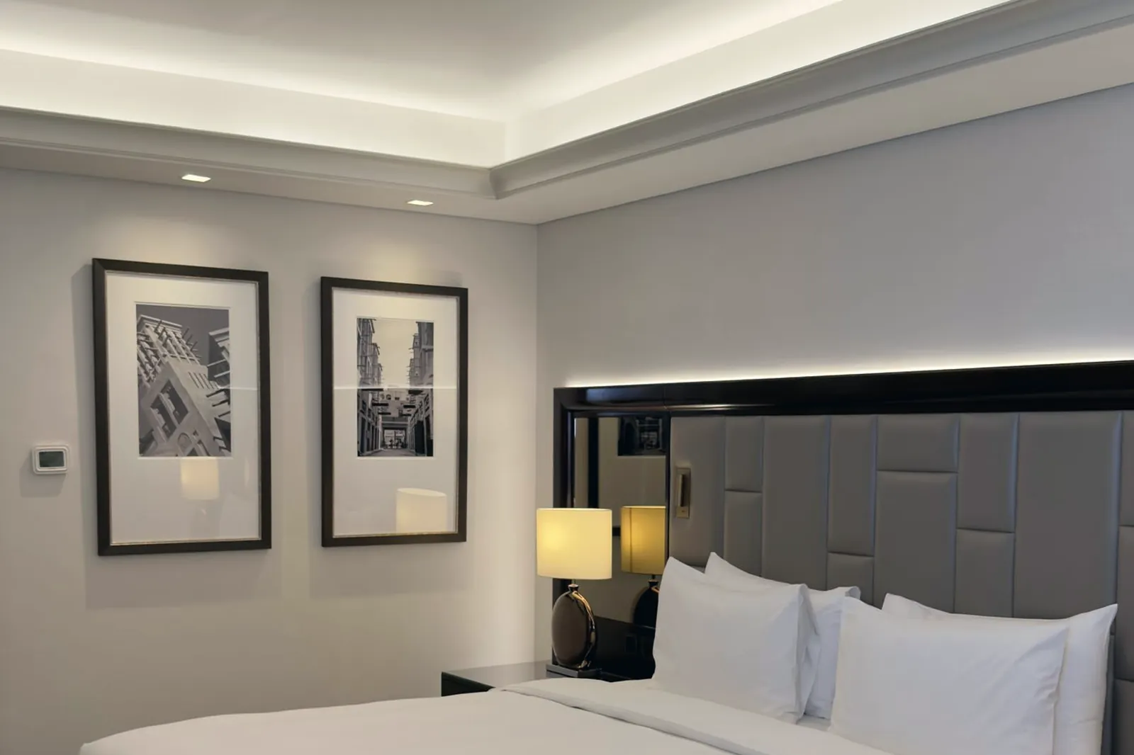 Chambre d’hôtel avec literie blanche impeccable et tête de lit en bois