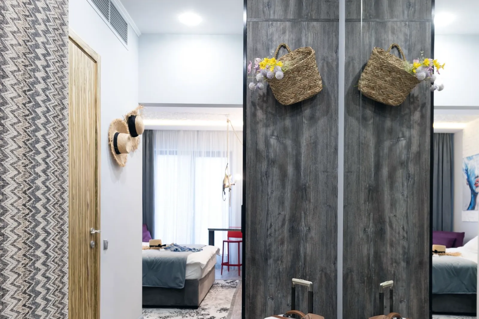 Couloir d’hôtel avec deux valises posées devant un miroir