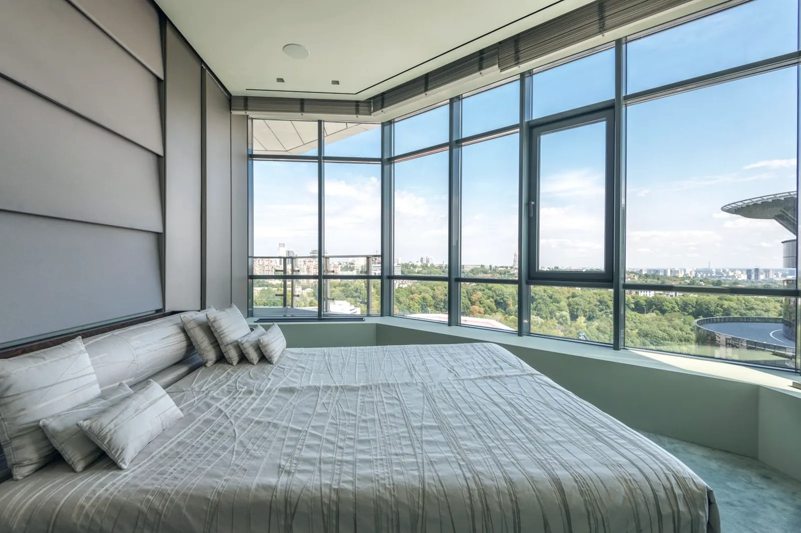 Chambre d’hôtel avec baies vitrées donnant sur une vue urbaine
