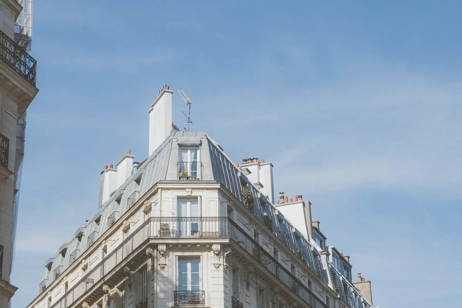 Immeuble parisien d’angle vu en contre-plongée sous un ciel dégagé
